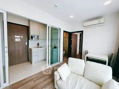 Modern apartment interior with open layout, featuring a cozy living area and compact kitchen.