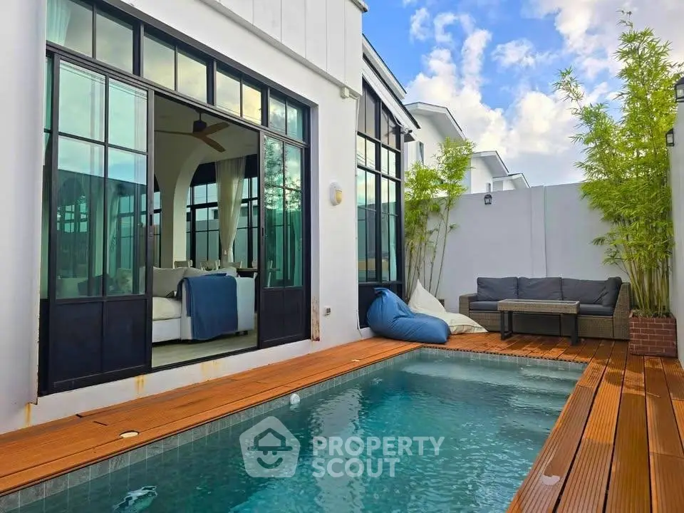 Luxurious modern home with private pool and stylish outdoor seating area, perfect for relaxation.