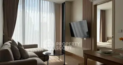 Modern living room with large windows and stylish decor in a contemporary apartment.