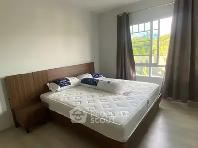 Spacious bedroom with large window and modern furnishings