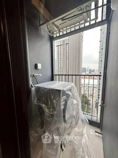 Compact balcony with washing machine and city view, ideal for urban living.