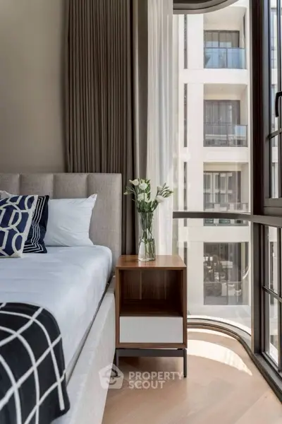 Modern bedroom with stylish decor and large window offering city view
