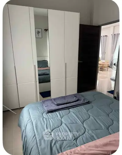 Cozy bedroom with modern wardrobe and neatly arranged bed in a stylish apartment.