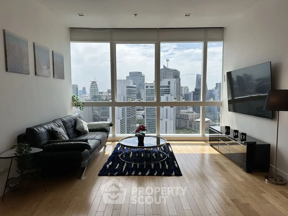 Modern living room with city view, sleek furniture, and floor-to-ceiling windows.