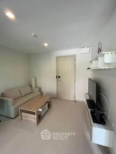 Modern living room with cozy sofa and flat-screen TV, perfect for relaxation.