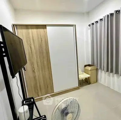 Modern minimalist bedroom with sliding wardrobe and wall-mounted TV, perfect for compact living spaces.