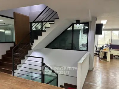 Modern office interior with sleek staircase and open workspace design