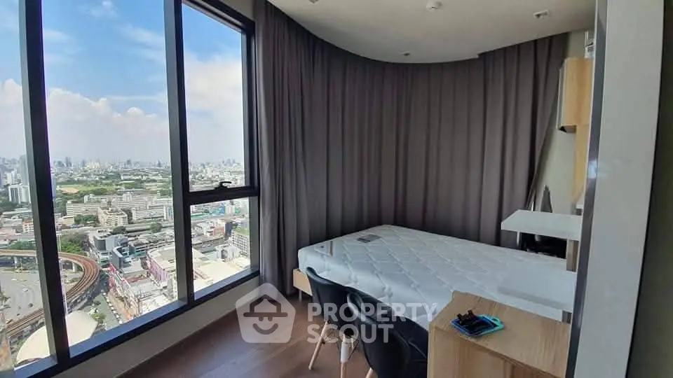 Stunning high-rise bedroom with panoramic city view and modern furnishings.