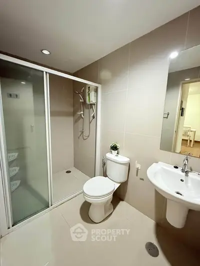 Modern bathroom with sleek shower and elegant fixtures in a contemporary apartment.