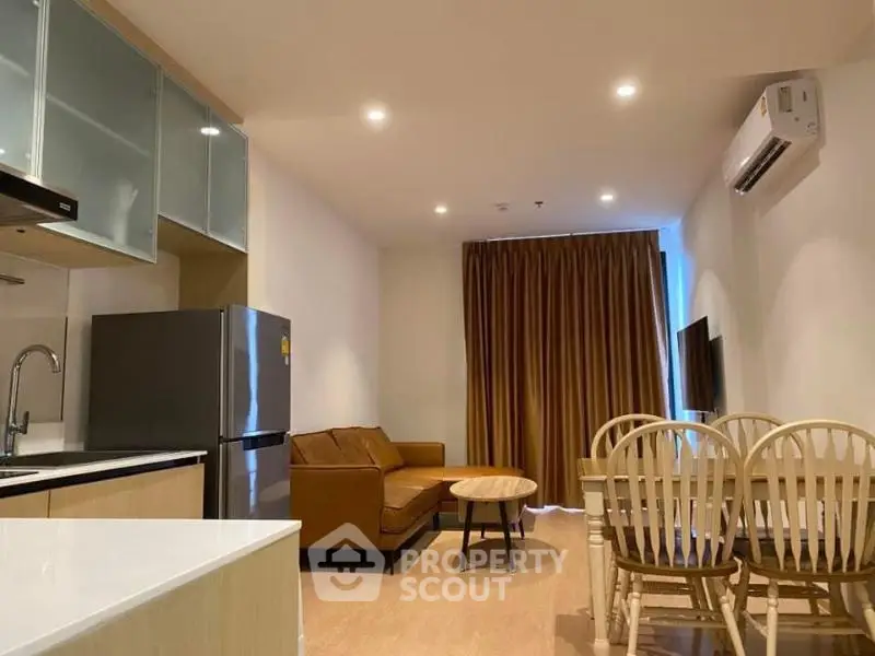 Modern living room with cozy seating and dining area in open layout apartment.