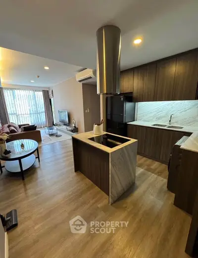 Modern open-layout kitchen and living room with stylish decor and natural light.