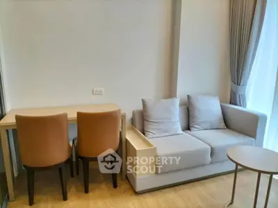 Modern living room with cozy sofa and dining area, featuring elegant decor and natural light.
