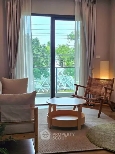 Charming living room with cozy seating and balcony view, perfect for relaxation and enjoying natural light.