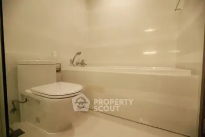 Modern bathroom with sleek white fixtures and a spacious bathtub.