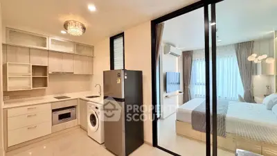 Modern apartment with open kitchen and cozy bedroom, featuring sleek appliances and elegant lighting.
