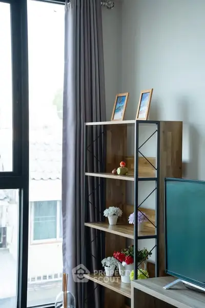 Modern living room with stylish shelving and large window offering natural light.