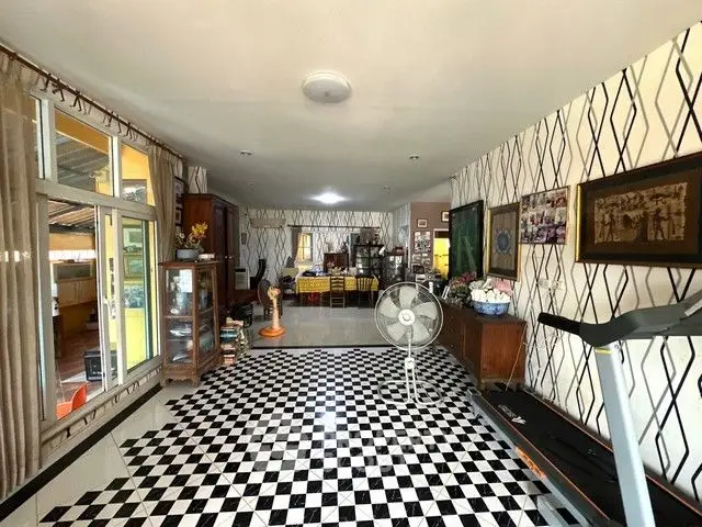 Spacious living room with checkered floor and treadmill, perfect for relaxation and fitness.