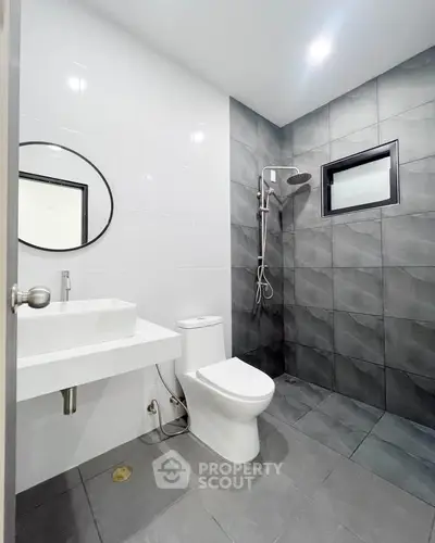Modern bathroom with sleek design, featuring a walk-in shower and contemporary fixtures.