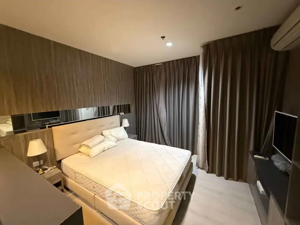 Modern bedroom with cozy lighting and stylish decor, featuring a comfortable bed and elegant curtains.