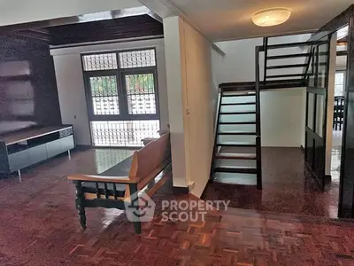 Spacious living room with wooden flooring and modern staircase