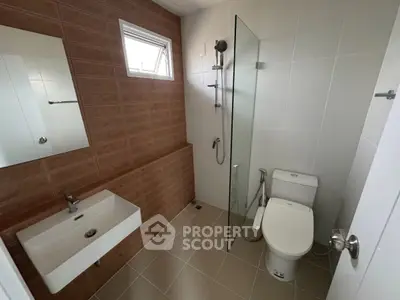 Modern bathroom with sleek design, featuring a glass shower partition and stylish fixtures.