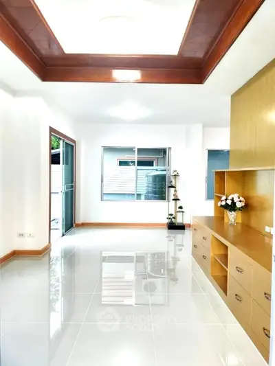Spacious modern living room with elegant built-in shelving and glossy tiled floors.