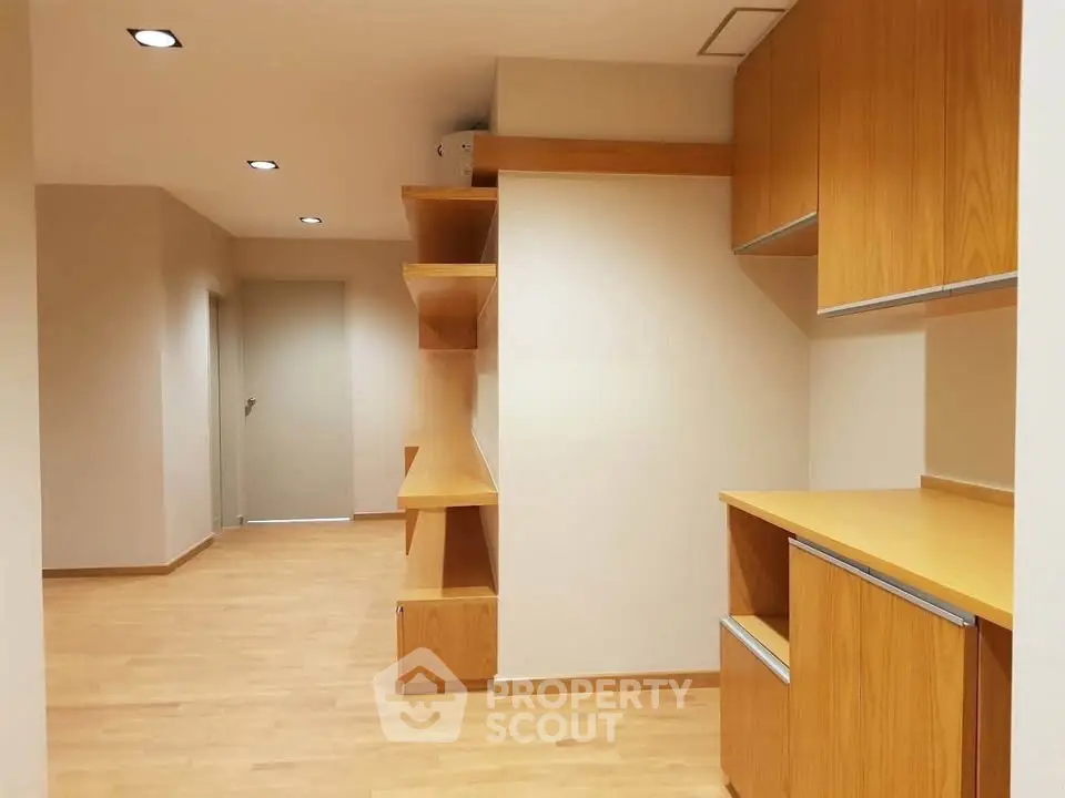 Spacious modern interior with wooden cabinetry and sleek lighting, perfect for versatile living or office space.