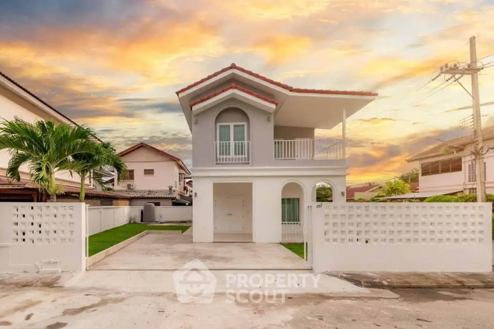 Charming two-story house with a beautiful sunset backdrop, featuring a spacious driveway and modern architecture.
