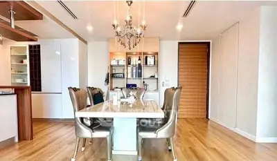 Elegant dining area with chandelier and modern decor in a luxurious apartment.