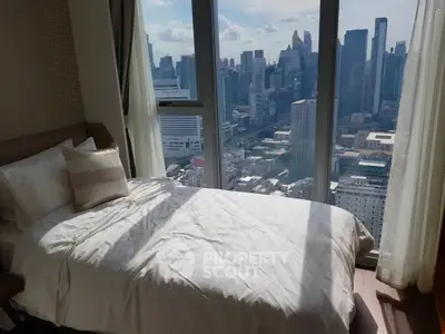 Luxurious bedroom with stunning city skyline view from floor-to-ceiling windows.
