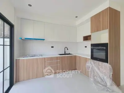 Modern kitchen with sleek cabinetry and built-in oven in a bright, minimalist design.