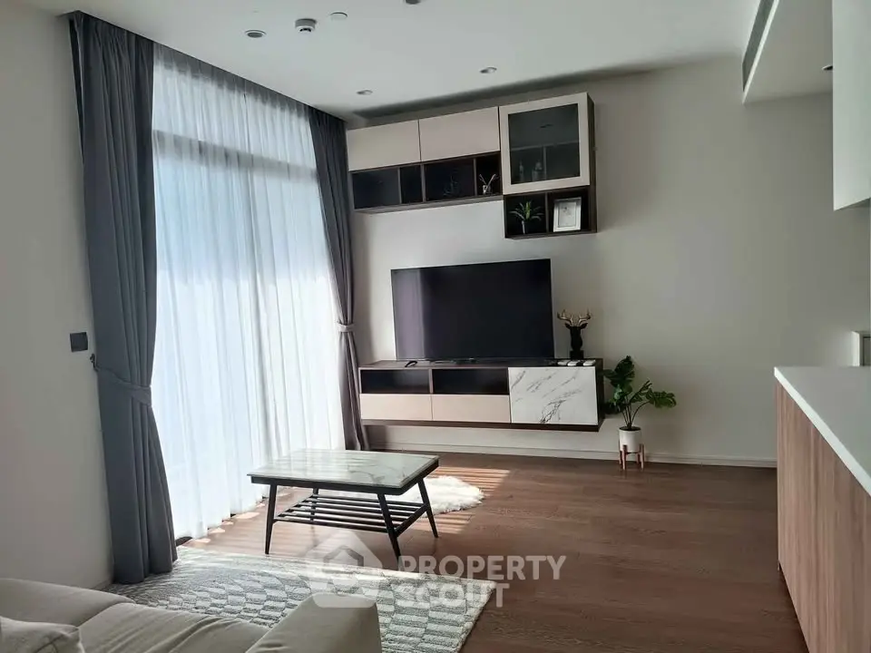 Modern living room with large window, sleek furniture, and stylish decor