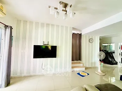 Spacious living room with modern decor and wall-mounted TV