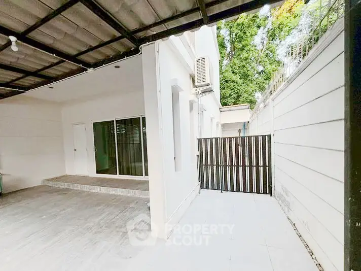 Spacious modern home exterior with covered patio and secure gate