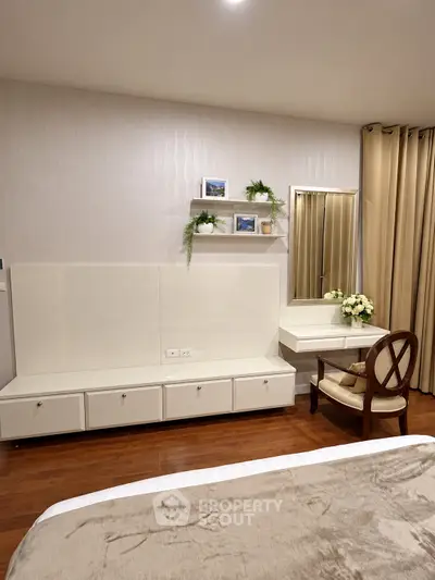Elegant bedroom with modern furniture and decorative accents, featuring a stylish vanity and cozy ambiance.