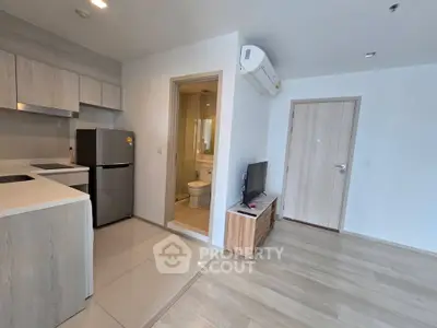 Modern apartment interior with open kitchen and living area, featuring sleek appliances and minimalist design.