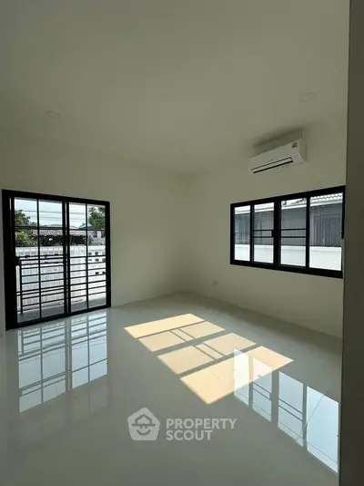Spacious empty room with large windows and natural light, perfect for customization.