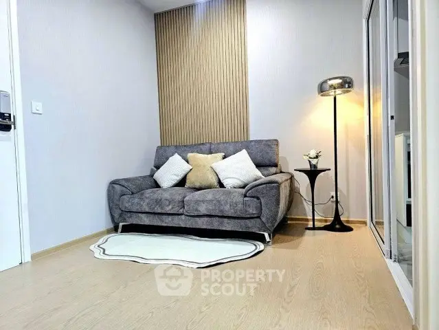 Modern living room with stylish sofa and floor lamp, featuring elegant decor and cozy ambiance.