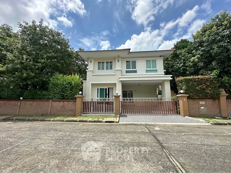 Charming two-story house with lush greenery and spacious driveway in a serene neighborhood.