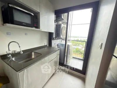 Modern kitchen with sleek cabinetry and balcony view
