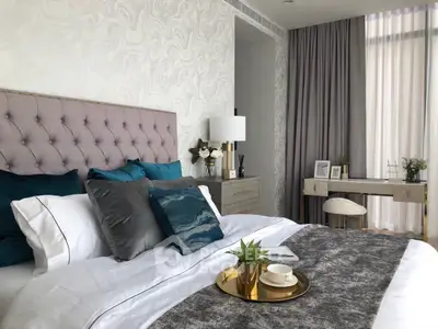 Luxurious bedroom with elegant decor and plush bedding in a modern apartment.