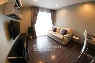 Modern living room with cozy sofa, wall-mounted TV, and elegant curtains in a stylish apartment.