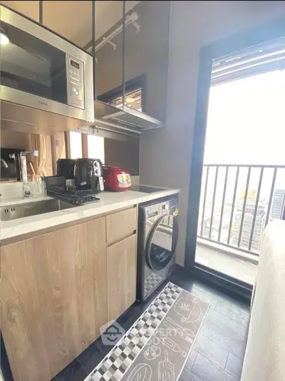 Modern kitchen with balcony view, featuring sleek appliances and stylish design.