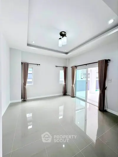 Spacious empty room with glossy tiled floor and large windows