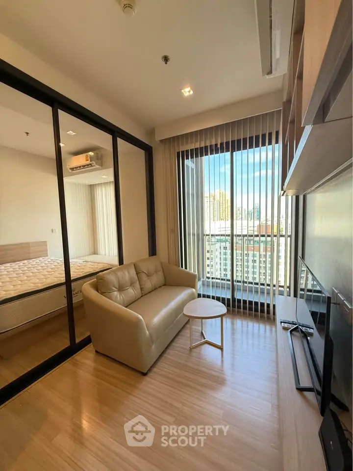 Modern living room with glass partition, cozy sofa, and city view from large windows.