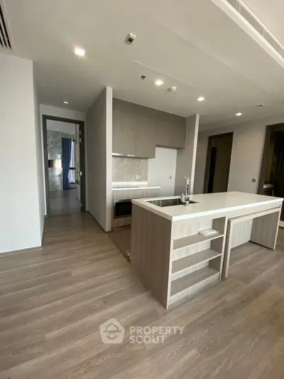 Modern open-layout kitchen with sleek design and island in a spacious apartment.