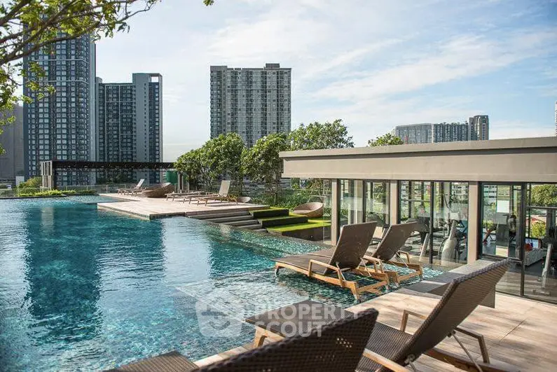 Luxurious rooftop pool with stunning city skyline views and modern lounge chairs.