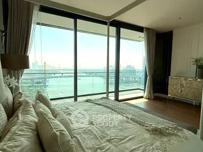 Luxurious bedroom with stunning river view and floor-to-ceiling windows in modern apartment.