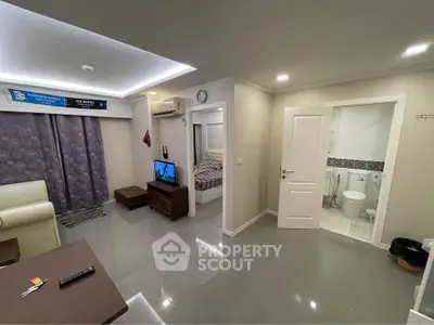 Modern apartment interior with open living area and visible bedroom and bathroom.