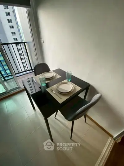 Cozy dining area with modern table set near balcony in high-rise apartment